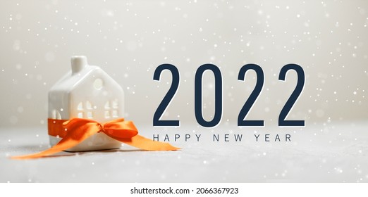 Merry christmas and 2022 happy new year horizontal banner with small toy model house wrapped in red satin ribbon on a white background - Shutterstock ID 2066367923