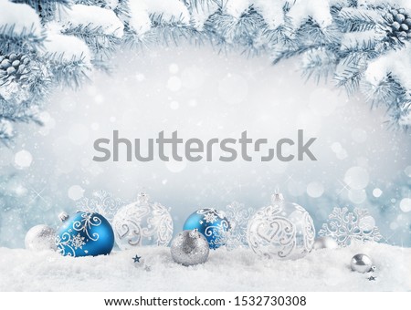 Merry Christmas card. Blue christmas balls and baubles on the snow with fir branches.