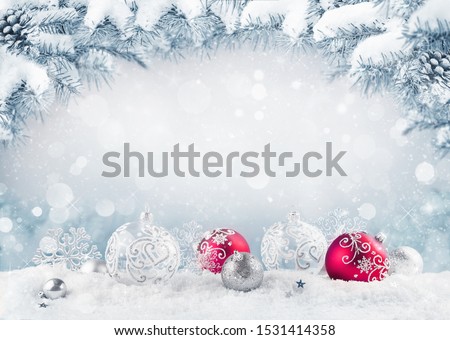 Merry Christmas card. Red christmas balls and baubles on the snow with fir branches.
