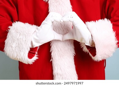 Merry Christmas, Cheerful senior man with hand gesture of Heart-shaped, mini heart, love, wearing Santa Claus costume isolated on yellow and blue background. Merry Xmas - Powered by Shutterstock