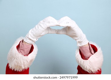 Merry Christmas, Cheerful senior man with hand gesture of Heart-shaped, mini heart, love, wearing Santa Claus costume isolated on yellow and blue background. Merry Xmas - Powered by Shutterstock