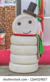 Merry Christmas Concept, A Snowman Made From Old Used Car Tires, Painted White.