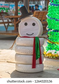 Merry Christmas Concept, A Snowman Made From Old Used Car Tires, Painted White.