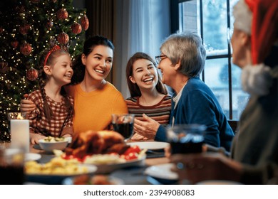 Merry Christmas! Happy family are having dinner at home. Celebration holiday and togetherness near tree. - Powered by Shutterstock