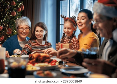 Merry Christmas! Happy family are having dinner at home. Celebration holiday and togetherness near tree. - Powered by Shutterstock