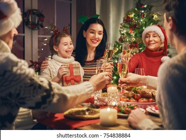 Merry Christmas! Happy family are having dinner at home. Celebration holiday and togetherness near tree.