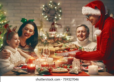 Merry Christmas! Happy Family Are Having Dinner At Home. Celebration Holiday And Togetherness Near Tree.