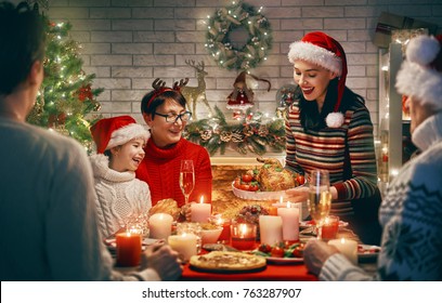 Merry Christmas! Happy Family Are Having Dinner At Home. Celebration Holiday And Togetherness Near Tree.