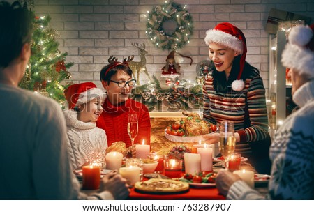 Merry Christmas! Happy family are having dinner at home. Celebration holiday and togetherness near tree.