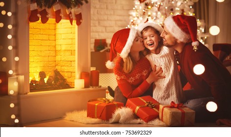 Merry Christmas! Happy Family Mother Father And Child With Magic Gift Near Tree