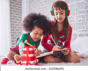 Merry Christmas and Happy Holiday with international kid,Children celebrating Christmas with Draw pictures on the book - Powered by Shutterstock