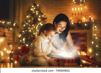 Merry Christmas And Happy Holiday! Loving Family Mother And Child With Magic Gift Box.