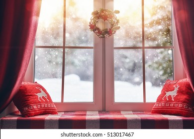 Merry Christmas and Happy Holidays! A beautiful decorated for Christmas window. Winter forest from the window of the house.
