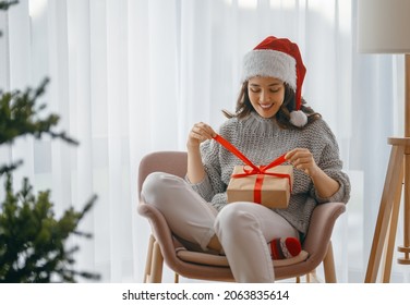 Merry Christmas, Happy Holidays. Cheerful pretty young woman having got a Christmas present. 