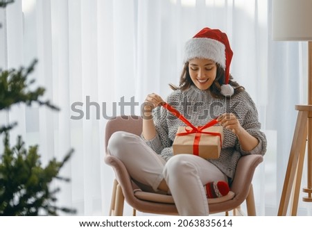 Merry Christmas, Happy Holidays. Cheerful pretty young woman having got a Christmas present. 