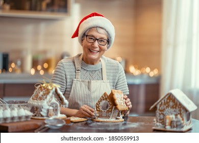 Merry Christmas and Happy Holidays. Family preparation holiday food. Woman cooking gingerbread house.