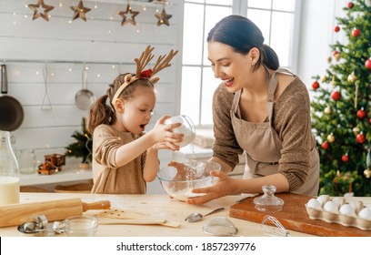 Merry Christmas and Happy Holidays. Family preparation holiday food. Mother and daughter cooking cookies. - Powered by Shutterstock