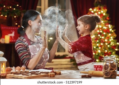 Merry Christmas And Happy Holidays. Family Preparation Holiday Food. Mother And Daughter Cooking Christmas Cookies.