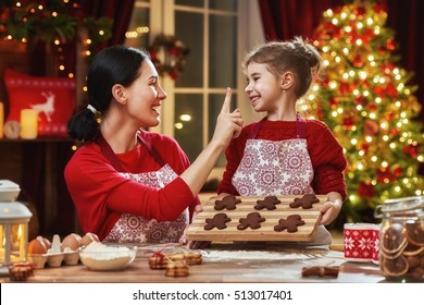 Merry Christmas And Happy Holidays. Family Preparation Holiday Food. Mother And Daughter Cooking Christmas Cookies.