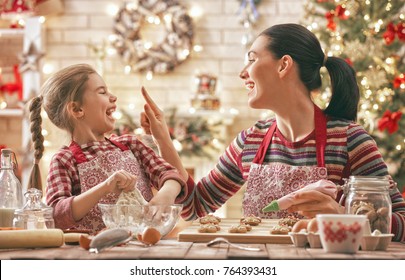 Merry Christmas And Happy Holidays. Family Preparation Holiday Food. Mother And Daughter Cooking Cookies.