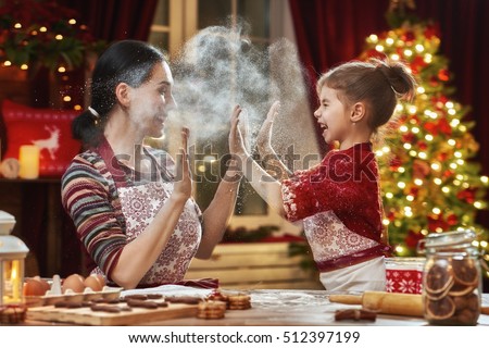 Merry Christmas and Happy Holidays. Family preparation holiday food. Mother and daughter cooking Christmas cookies.