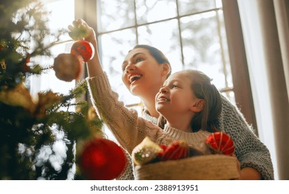 Merry Christmas, Happy Holidays. Mom and daughter near the tree indoors. The morning before Xmas. 