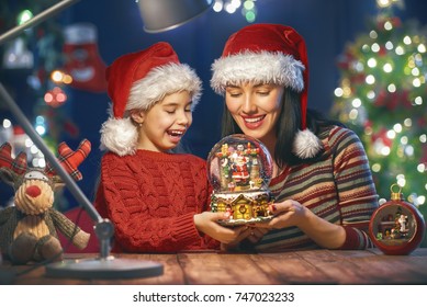 Merry Christmas and Happy Holidays!  Mom and daughter near the tree in room at home. Loving family indoors. - Powered by Shutterstock