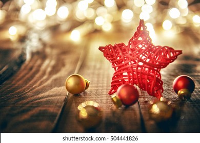 Merry Christmas and Happy Holidays! Red star, Christmas baubles and garland lights on old dark wooden rustic background. - Powered by Shutterstock