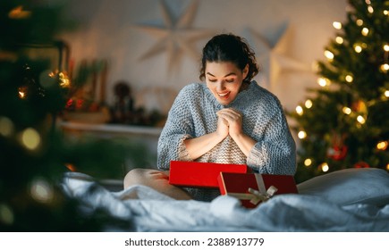 Merry Christmas, Happy Holidays. Surprised happy woman opening a Christmas present.  - Powered by Shutterstock