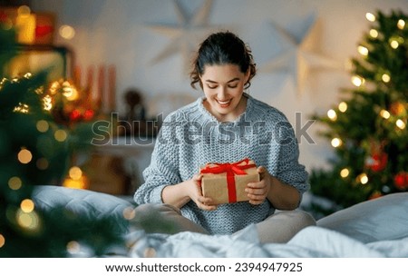 Merry Christmas, Happy Holidays. Surprised happy woman opening a Christmas present. 