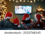 Merry Christmas and Happy New Year. People having fun near tree indoors. Loving family watching holiday movies at home. Mother, father and daughters spending time together.