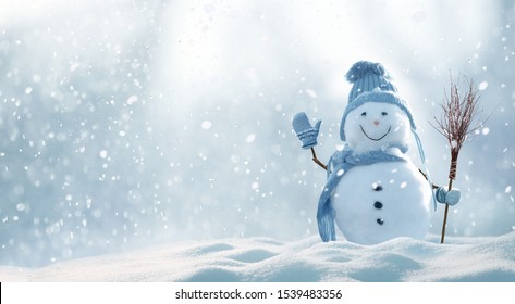 Поздравительная открытка с Рождеством и Новым Годом с копированием.Счастливый снеговик стоит в рождественском пейзаже.Снежный фон.Зимняя сказка.