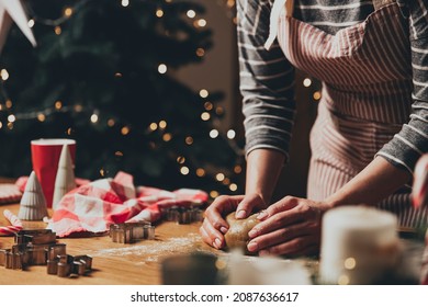 Merry Christmas, Happy New Year. Woman is cooking gingerbread cookies or baking Christmas cake or strudel at kitchen on wooden table, massaging dough. High quality photo