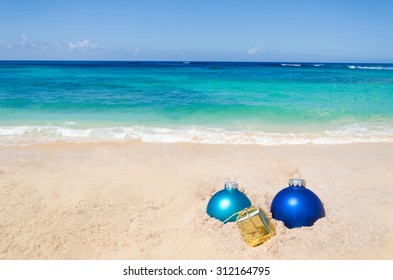 Merry Christmas And Happy New Year Background With Gift And Balls On The Tropical Beach Near Ocean In Hawaii