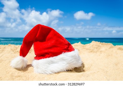 Merry Christmas And Happy New Year Background With Santa Claus Hat On The Tropical Beach Near Ocean In Hawaii