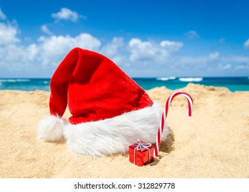 Merry Christmas And Happy New Year Background With Santa Claus Hat And Starfish On The Tropical Beach Near Ocean In Hawaii