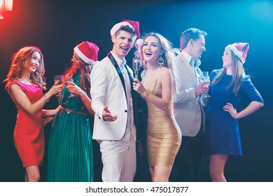 Merry Christmas and Happy New Year! Party and celebration. Group of six happy smiling friends having fun together, singing karaoke in the club. - Powered by Shutterstock