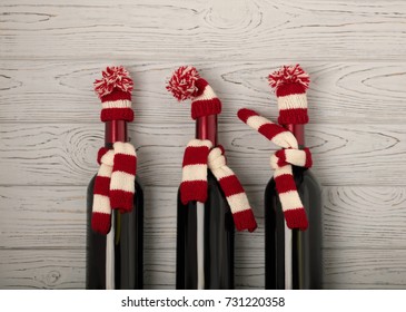 Merry Christmas And A Happy New Year! Bottles Of Wine In A Knitted Cap Of Santa Claus. Selective Focus