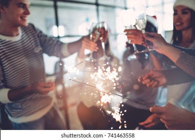 Merry Christmas And Happy New Year 2018!Multiracial Young Creative People Are Celebrating Holiday In Modern Office.Group Of Business People Drinking Champagne With Sparkling Bengal Lights In Coworking