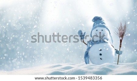 Merry christmas and happy new year greeting card with copy-space.Happy snowman standing in christmas landscape.Snow background.Winter fairytale.