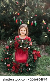 Merry Christmas. Portrait Of Happy Funny Child Girls In Santa Hat With Christmas Wreath. Happy Holidays. Fairy Magic. Happy Kid Enjoying Holiday. Christmas In July