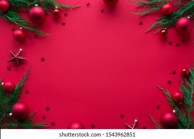 Merry Christmas red background decorated with happy 2022 new year tree branches and baubles stars, winter holiday card decorations festive merry concept, flat lay, above top view, copy space