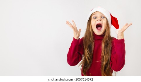 Merry christmas. Sale, discount, win, winner concept. Impressed, emotion, child girl look at camera with open mouth, happy eyes. Baby wearing santa hat isolated white background