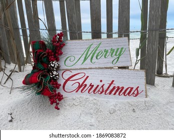 Merry Christmas Sign With Wood Fence Background On White Sand Florida Beach