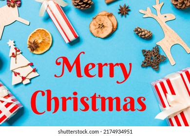 Merry Christmas text. Top view of Christmas decorations on blue background. New Year holiday concept with copy space. - Shutterstock ID 2174934951