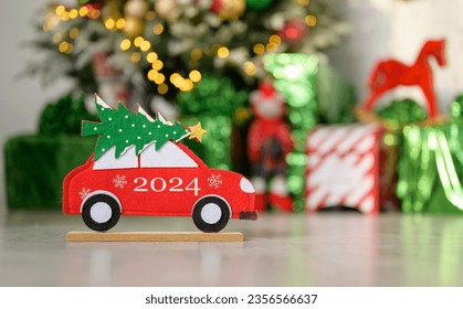 Merry Christmas wish on a toy car on the background of a Christmas tree and gifts. Happy New Year 2024 - Powered by Shutterstock