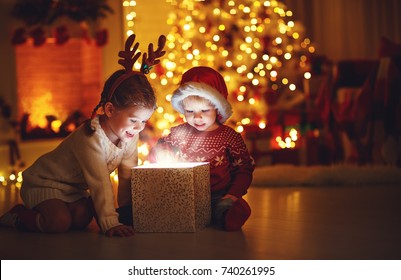 Merry Christmas!happy children with magic gift at home near  Christmas tree and fireplace - Powered by Shutterstock