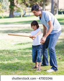 Merry Father Playing Baseball With His Son In The Park