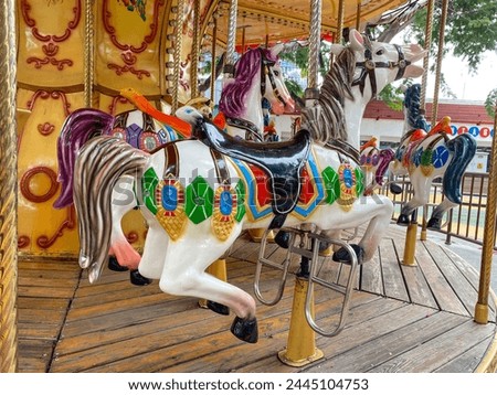 Merry Go Round carousel At Local County Fair in Indonesia. Colorful carousel horse on a vintage illuminated roundabout carousel (merry go round) in a park