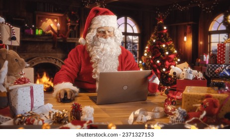 Merry Santa Claus Sitting Behind a Desk and Working on Laptop Computer. Senior Santa Shopping Online, Fulfilling Gift Orders for Christmas and New Year. Advertising Footage for Winter Holidays
